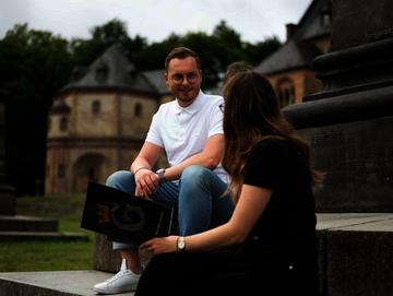 Zwei Personen sitzen vor der Kaiserpfalz und unterhalten sich über Ausbildungsplätze bei der Stadt Goslar