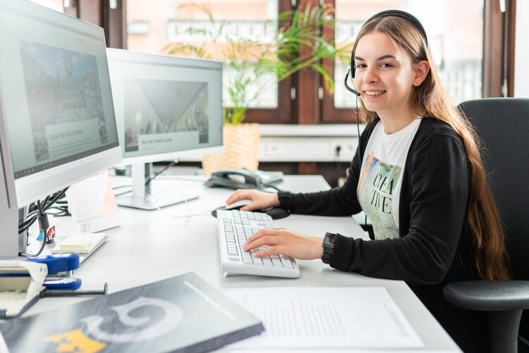 Eine junge Frau sitzt vor einem Computer